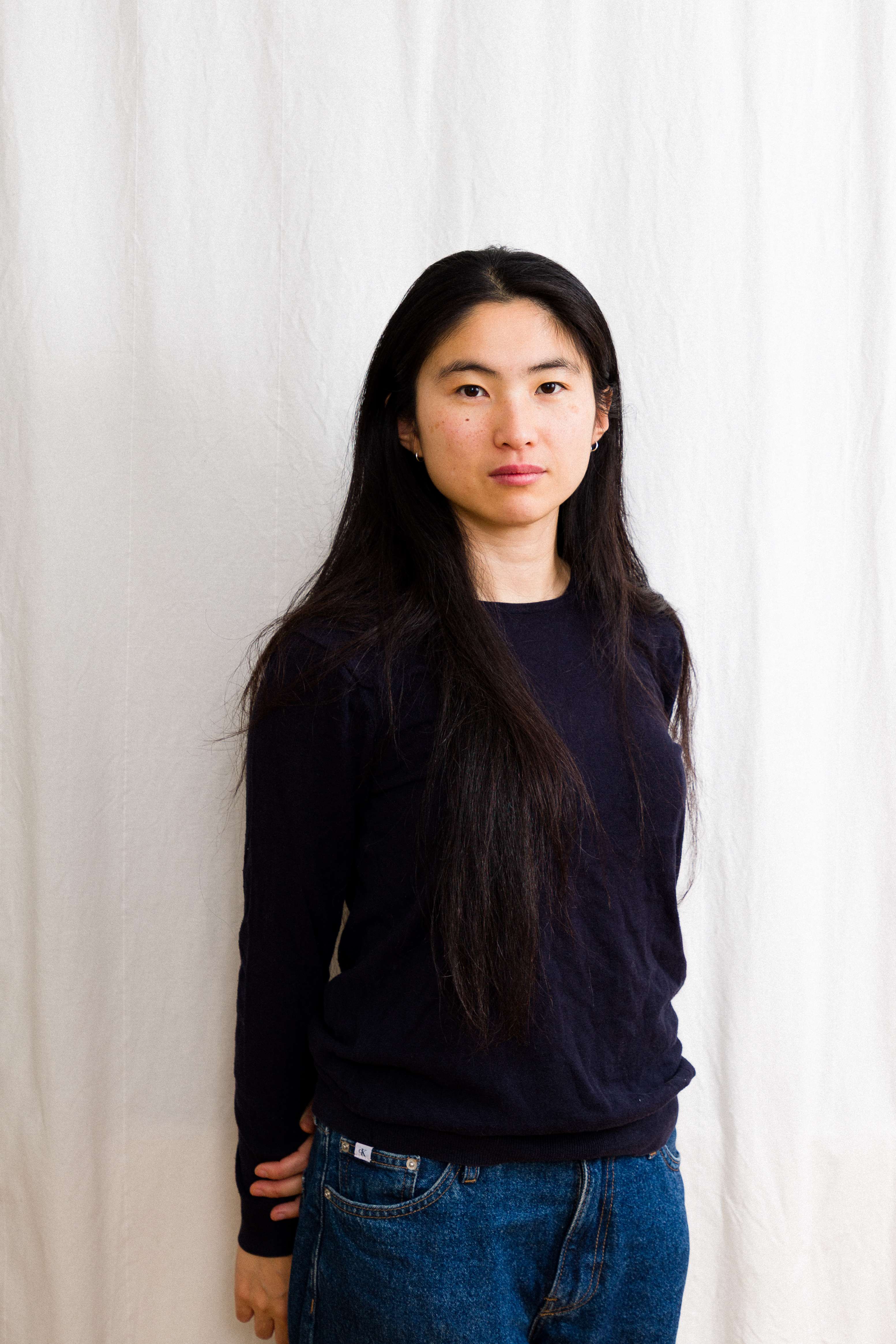 Portrait of Kim Hye Jung against a textured paper backdrop